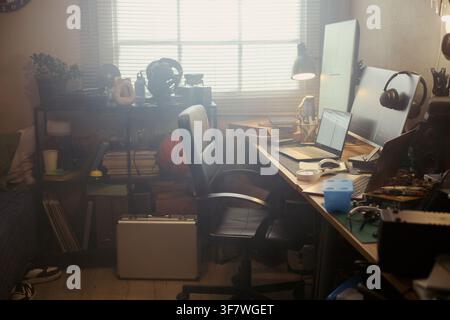 Empty home office workspace featuring multiple computer monitors, laptop, and office chair. Scene represents remote work setup, suitable for remote employment and technology marketing Stock Photo