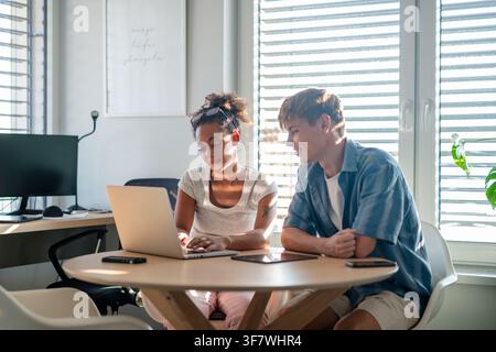 University students working together on laptop during study session. Stock Photo