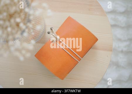 Leather notebook on a wooden table with vase Stock Photo