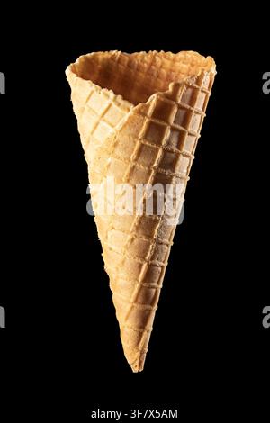 Empty waffle ice cream cone isolated on black background, vertical Stock Photo