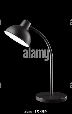 Modern black desk lamp turned on isolated on black background, vertical Stock Photo