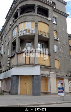 Boarded up windows due to bomb and drone attack damage in Kharkiv, eastern Ukraine, painted with street art. May 2026 Stock Photo