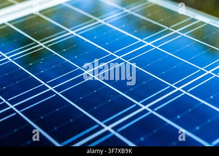 Solar panel surface background close-up. Solar technology concept. Detailed macro shot of a modern blue photovoltaic solar panel surface, highlighting the grid pattern, semiconductor cells, and technology used for clean and renewable energy generation. Stock Photo