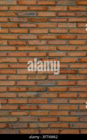 A close up texture of a brick wall featuring bricks in warm orange and brown tones. The clay bricks show natural color variations, ranging from terrac Stock Photo