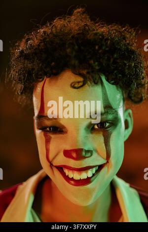 Portrait of Smiling Child Wearing Scary Clown Makeup for Halloween Stock Photo