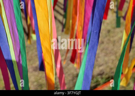 Vibrant multi colored satin ribbons hanging backdrop Stock Photo