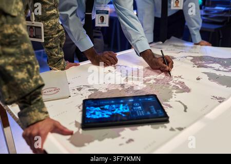 Military Officers and Analysts Planning Strategy on World Map Stock Photo