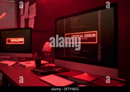 Computer Screen Displaying Critical Error Message in Dark Office Stock Photo