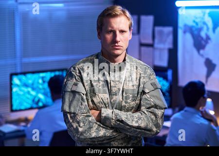 Portrait of Man in Military Uniform Standing with Arms Crossed in Office Stock Photo