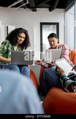 Diverse group collaborating on laptops Stock Photo
