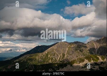 Dramatic clouds pass over a rocky mountain range Stock Photo
