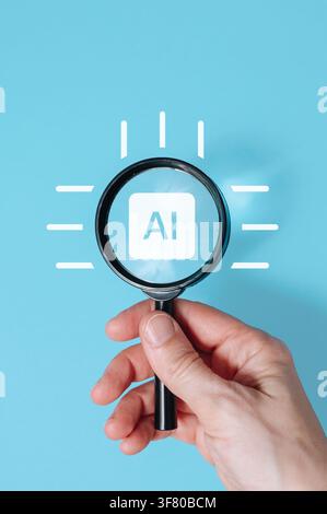Hand holding magnifying glass over AI artificial intelligence sign on blue background, tech innovation search concept. High quality photo Stock Photo