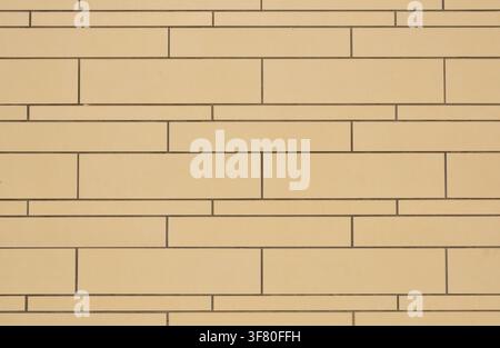 Wall of beige brown tiles in various elongated formats placed horizontally. Front view. Stock Photo
