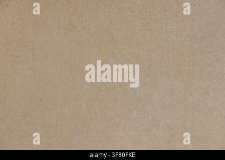 Close-up of natural brown cardboard surface with subtle fibers and organic texture. Ideal as a recyclable paper background, packaging mockup, or eco d Stock Photo