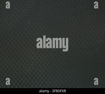 Close-up of black textured plastic with a repeating geometric pattern. Modern industrial surface ideal for backgrounds, product mockups, technology, o Stock Photo