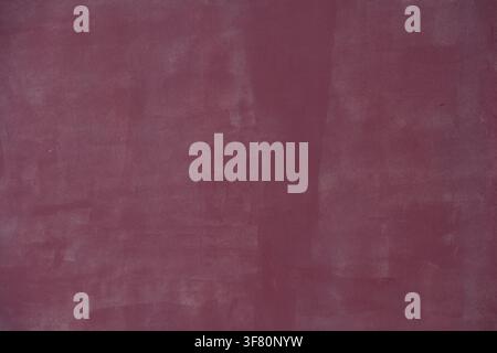 Wall with smooth dark pink plaster or stucco for use as a background texture Stock Photo