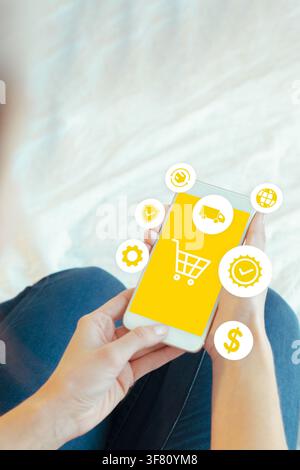 Online shopping with a smartphone in hand while sitting on a couch and exploring various products and services Stock Photo