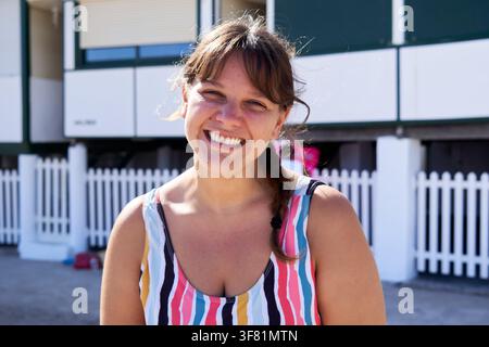 Cheerful woman looking at camera smiling at the beach. Stock Photo