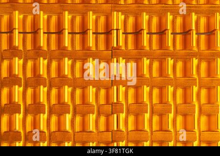 Golden tiles arranged in neat, repeating rows. Surface gleams under warm, direct light. Pattern suggests roof or architectural detail. Texture shows f Stock Photo