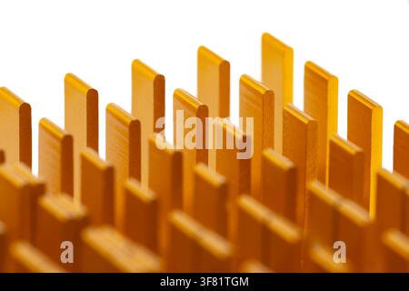 Golden fins rise sharply from a white surface. Each fin has a smooth, uniform texture. Light highlights edges, giving depth to structure. This close-u Stock Photo