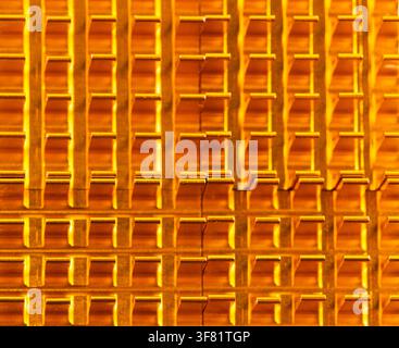 Golden lattice pattern gleams under warm light. Repeated geometric shapes create rhythmic visual texture. Surface shows precision, engineered for func Stock Photo
