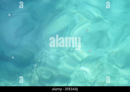 Soft focus image showing blue and green hues resembling ocean water with light reflections. Stock Photo