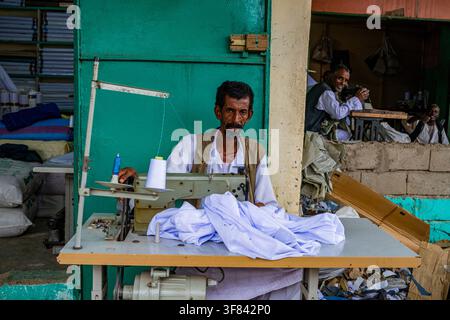 Tailor working in the busy market of Port Sudan, Sudan during a typical day of business Stock Photo