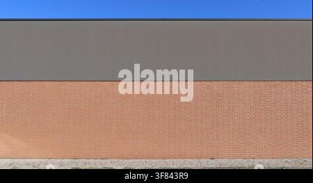 Large brick wall with the upper side gray plaster painted. Tiled sidewalk in front. Background for copy space. Stock Photo