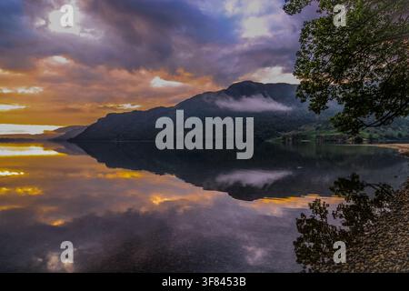 Sunrise over Ullswater in the Lake District provides a view of water and mountains in the early morning Stock Photo