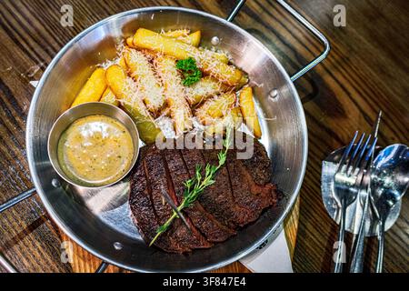 Medium Wagyu steak served with potato wedges and cheese in a restaurant in Vietnam Stock Photo