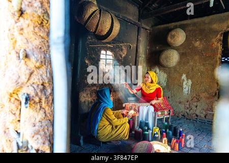 Cham women craft textiles in traditional workshop while working with colorful threads in Vietnam Stock Photo