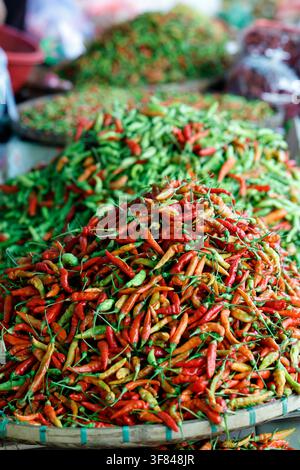 Chili peppers for sale at a market in Luang Prabang, Laos with various colors and sizes displayed in baskets Stock Photo