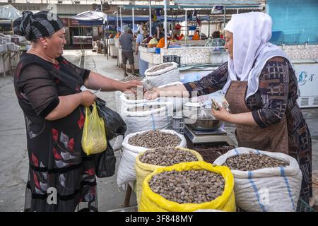 Busy food market scene where vendors sell nuts and dried fruits in Bukhara, Uzbekistan during the daytime Stock Photo