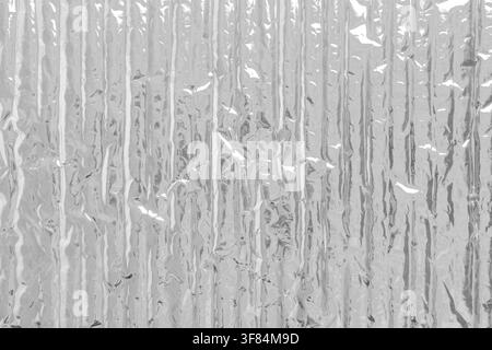 Silver foil bubble wrap insulation texture as an abstract industrial background. Textured plastic surface with vertical ridges Stock Photo