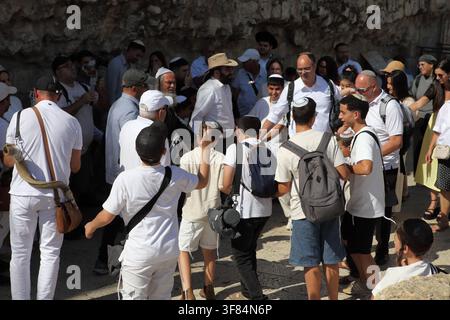 Bearded black wearing grandfather dances exuberantly with his son, his 13 years old grandson & other men at the boy's Bar Mitzva by the Western Wall. Stock Photo
