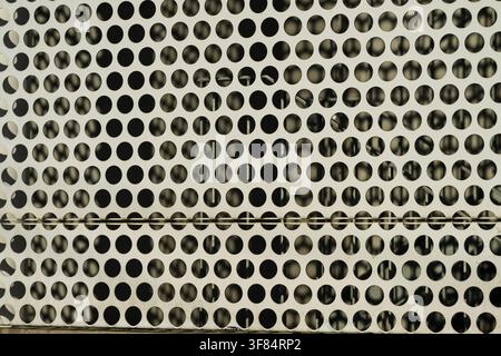 Patterned perforated metal panel with circular holes Stock Photo