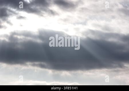 Sunbeams breaking through dramatic clouds in the sky. Stock Photo
