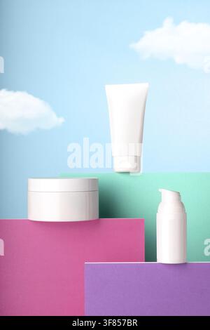 Blank White Cosmetic Skincare Products on Colorful Pedestals with Blue Sky Background. Stock Photo