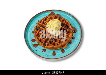 Belgian Waffle with Vanilla Gelato, Chocolate Syrup and Cookie Crumbs on Blue Plate Stock Photo