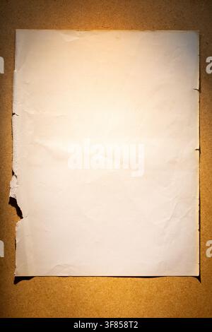 Vertical blank vintage paper sheet with torn edges on warm brown background for letter mockup or antique poster design Stock Photo