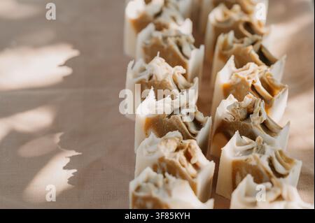 handmade soaps arranged on textured cloth surface close-up neutral mood beauty and personal care natural light clean background  Stock Photo