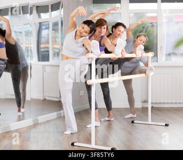 Group of women stretching at ballet barre Stock Photo