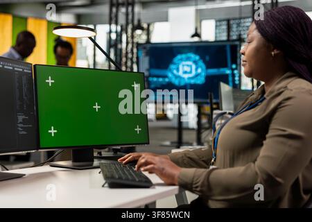Green screen PC used by Silicon Valley system administrator building scalable solutions for businesses. African american woman in AI startup office using mockup computer, leveraging deep learning tech Stock Photo