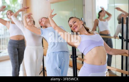 Slender women practicing ballet at ballet barre Stock Photo