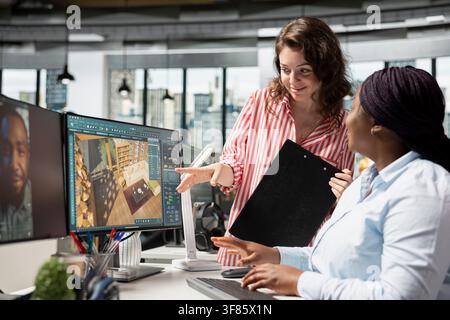 Diverse architect and engineer designing residential apartment layout using CAD architecture software on a PC. Employee works with digital modeling tools to create 3D render visuals, floor plan. Stock Photo