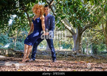 Couple dancing tango with passion and elegance outdoors in a lush park setting Stock Photo