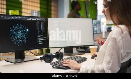Close up of IT expert coding with AI language model assistance in startup office, using PC. Young admin typing on computer keyboard integrating LLM assistant suggestions into code editor, camera A Stock Photo