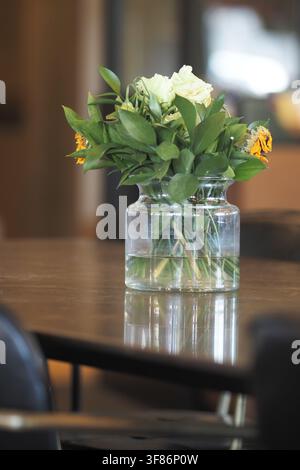 Flowers in a clear vase on a table in a cafe Stock Photo