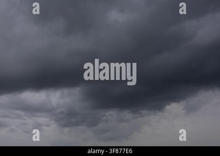 Ominous grey storm clouds gathering in the sky creating a dramatic dark atmosphere before a heavy summer thunderstorm or approaching hurricane Stock Photo