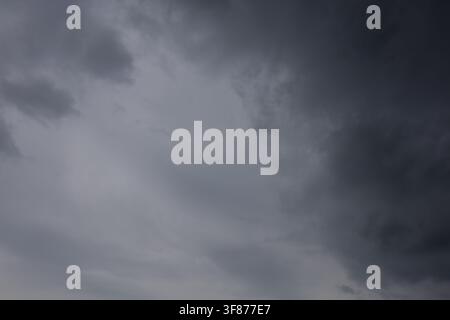 Ominous dark black storm clouds filling the entire sky creating a dramatic and threatening atmosphere before a heavy summer thunderstorm rainfall Stock Photo